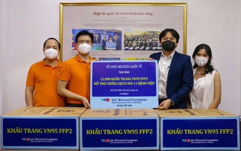 Ông Jin Hyun Ok (áo vàng đứng giữa) - Tổng thư ký Tổ chức WeLoveU Quốc tế chi nhánh tại Hà Nội cùng đại diện Soha trong buổi trao tặng 22.000 khẩu trang y tế, giúp các lực lượng tuyến đầu chống dịch.