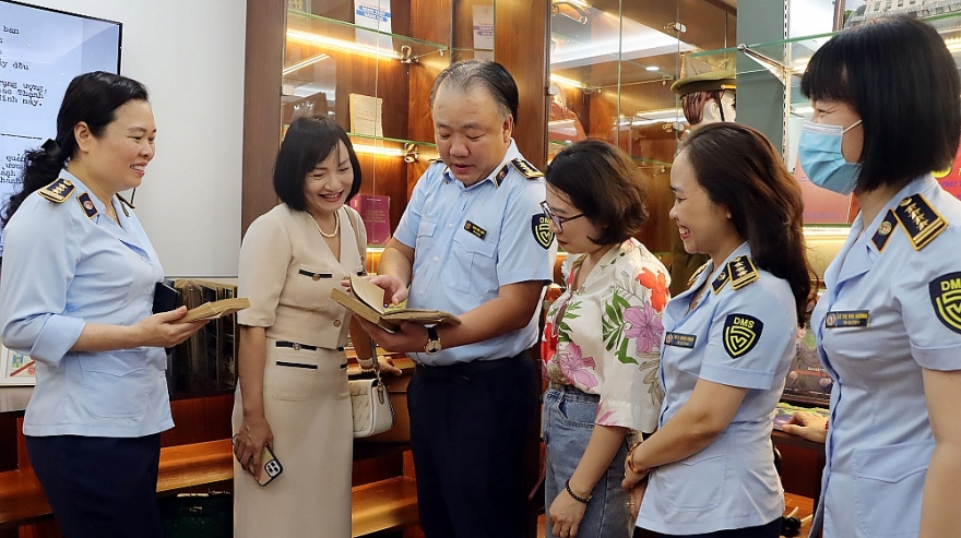 Tổng Cục trưởng Trần Hữu Linh giới thiệu với khách tham quan các tư liệu, hiện vật trong Phòng Trưng bày truyền thống “Dấu ấn Quản lý thị trường”