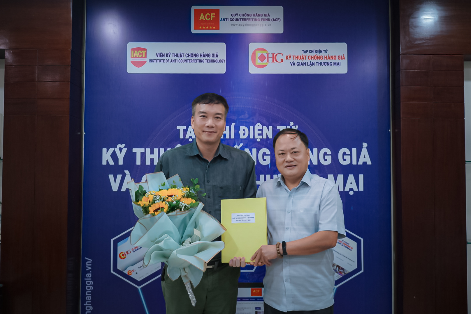 Ông Phạm Lộc Ninh, Viện trưởng Viện Kỹ thuật Chống hàng giả trao quyết định và tặng hoa chúc mừng cho TS. Nguyễn Đức Tài, Phó Viện trưởng Viện Kỹ thuật Chống hàng giả kiêm Chủ tịch Hội đồng Khoa học.